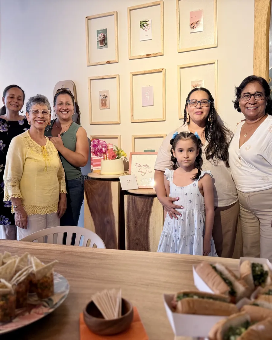 A shared table — Three generations, something to eat and flowers in the middle.