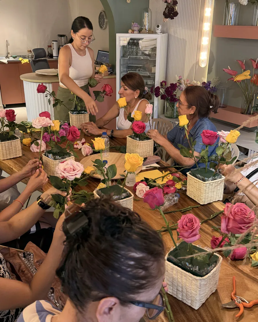 The work table — A seat, a pair of shears and a basket of flowers for everyone. The workshop starts when the table fills up.